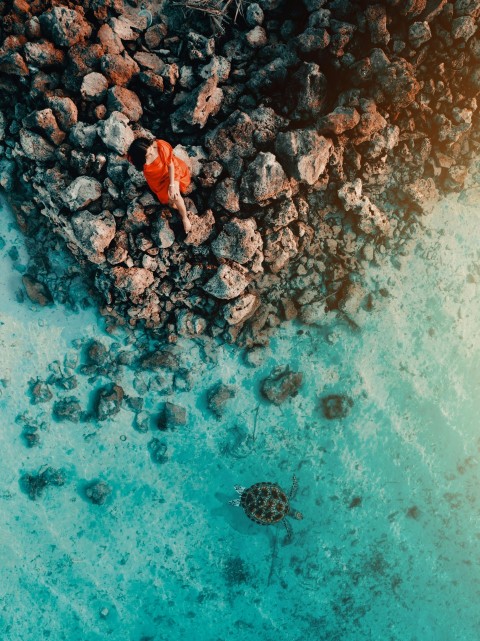 an aerial view of rocks and water in the ocean