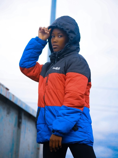 a woman in a blue red and black jacket