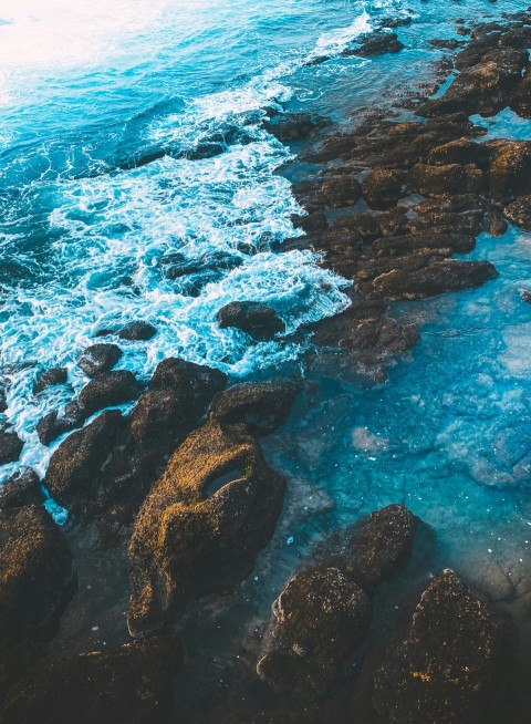 brown rock formation on body of water during daytime