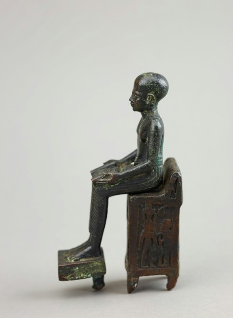 a statue of a man sitting on top of a box