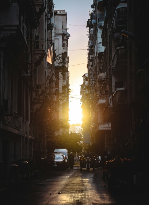 the sun is setting on a city street