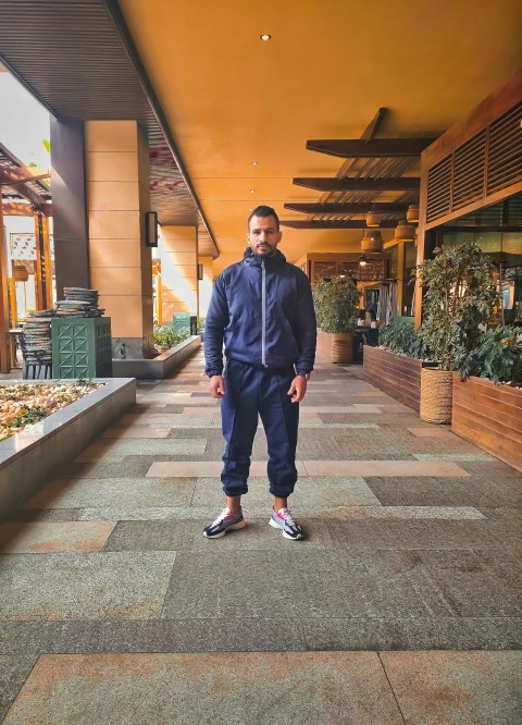 a man standing on a tiled walkway in a building