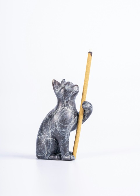 a statue of a bear holding a pencil