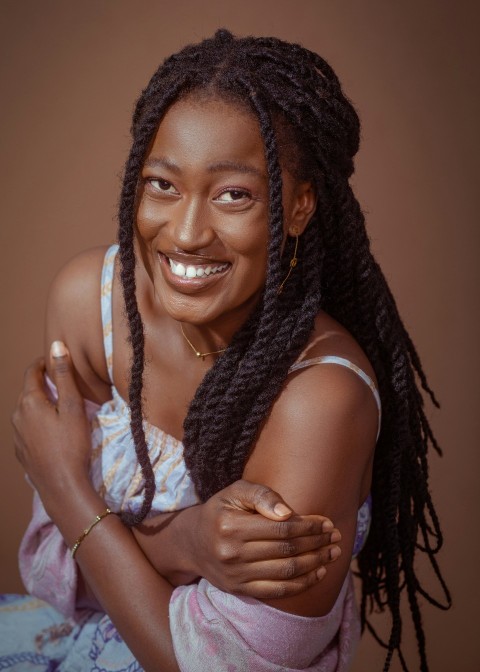 a smiling woman with braids on her hair