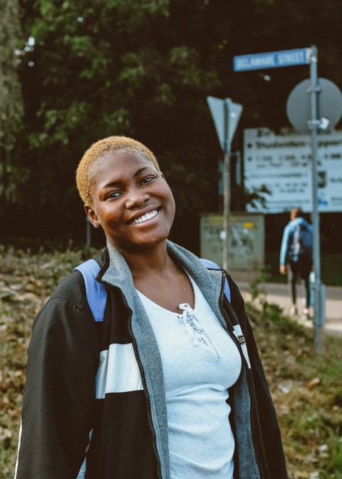a woman standing in front of a street sign F9bkOxw
