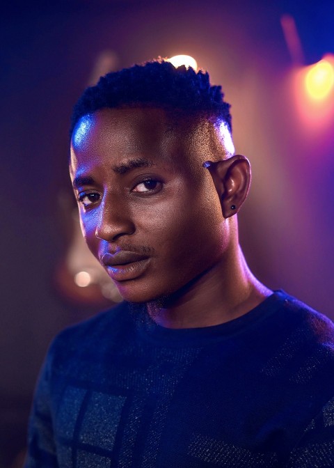 a young man with a mohawk standing in front of a stage