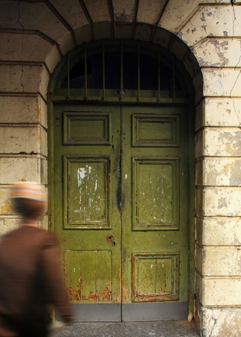 a man is walking past a green door