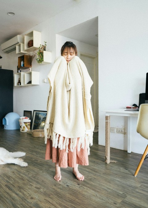 woman in white robe standing on brown wooden parquet floor