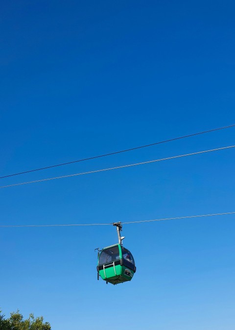 a person riding a ski lift on a clear day ip5MPN5Wm