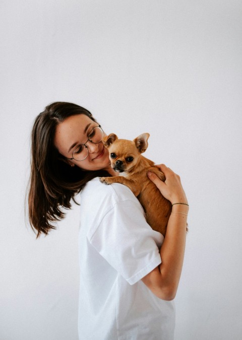 a woman holding a small dog in her arms