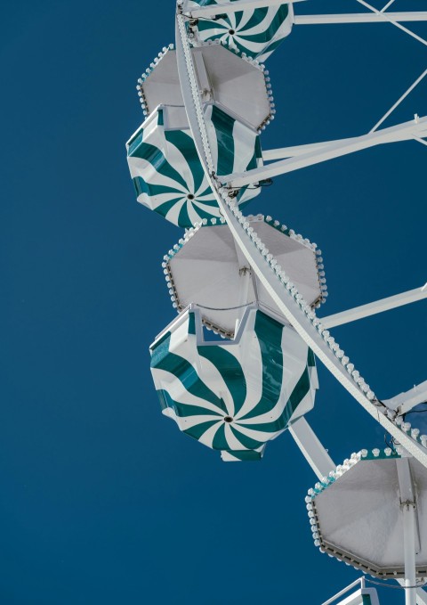 a green and white ferris wheel against a blue sky cSwwzyB2