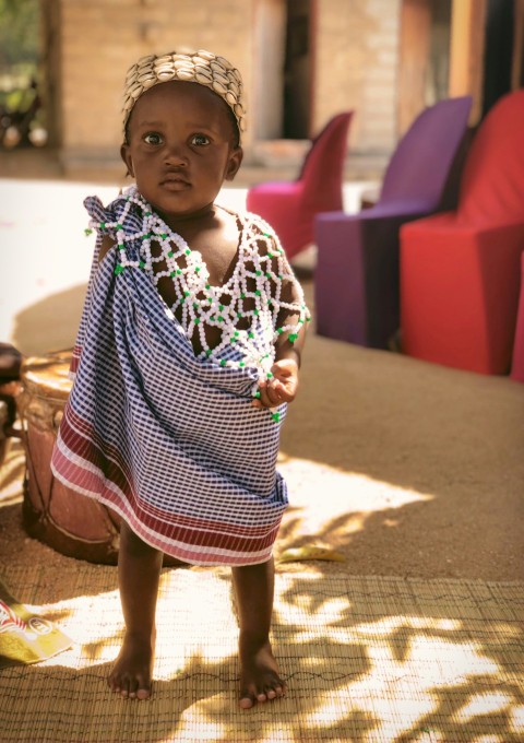 girl in white and black stripe dress standing on brown sand during daytime