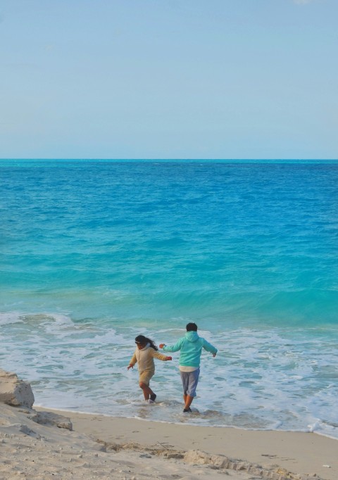 a couple of people that are walking in the water