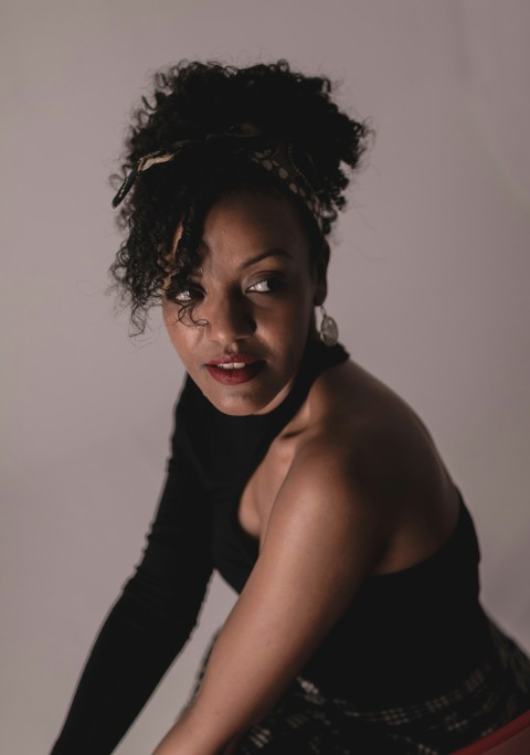 a woman in a black top is holding a tennis racquet