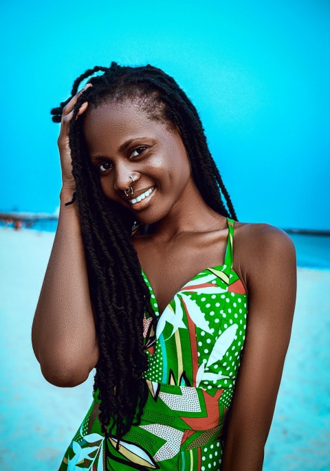 a woman with dreadlocks standing on a beach