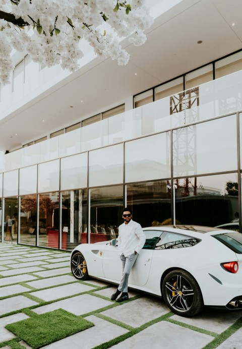 man in white dress shirt beside coupe