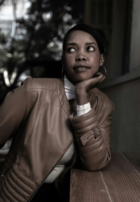 a woman sitting at a table with her hand on her chin