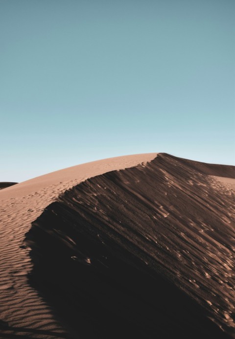 a person standing on top of a sand dune 9w