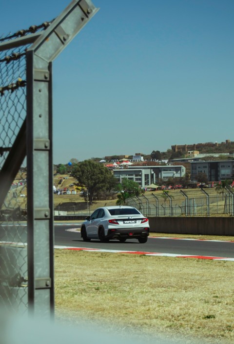 a white car driving down a race track