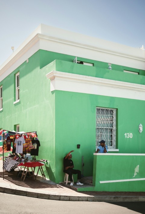 a green building with a woman sitting at a table