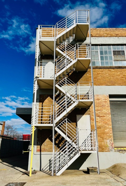 a tall building with a fire escape next to it _