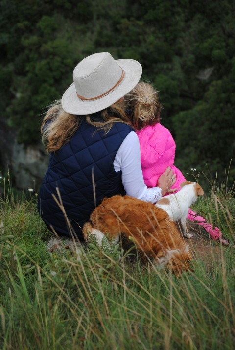 woman girl and two dogs sitting on grass