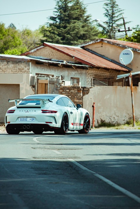 a white sports car parked on the side of the road