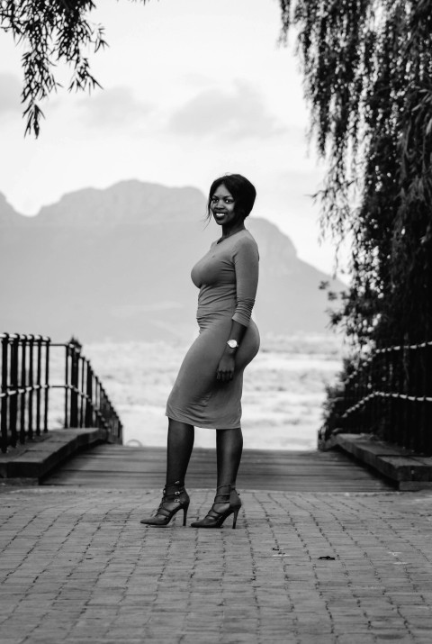 woman in tank top and leggings standing on wooden dock