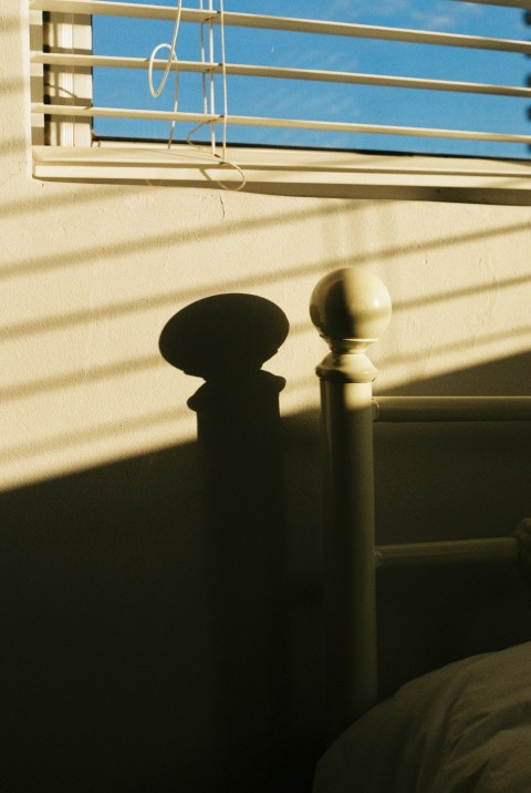 a bed sitting under a window next to a window sill