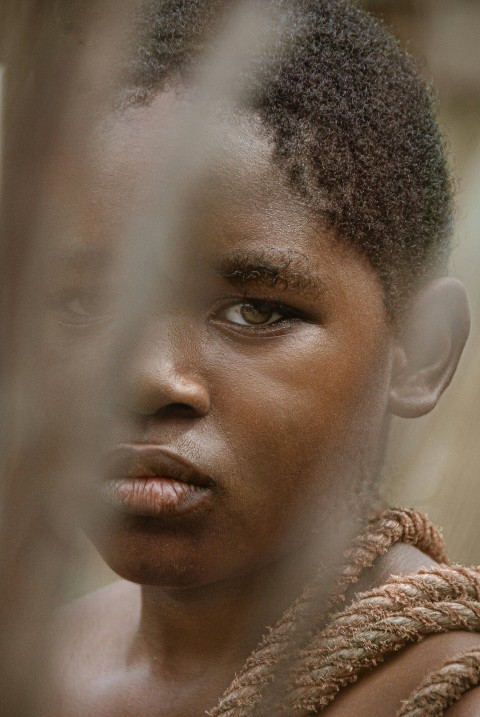 a close up of a person behind a fence