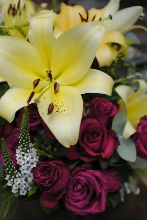 a bouquet of yellow lilies and red roses