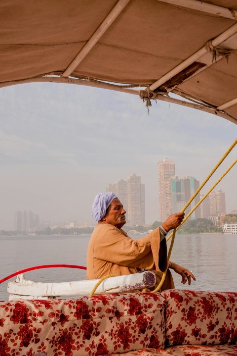 a man sitting on a boat in the water XvQ2m