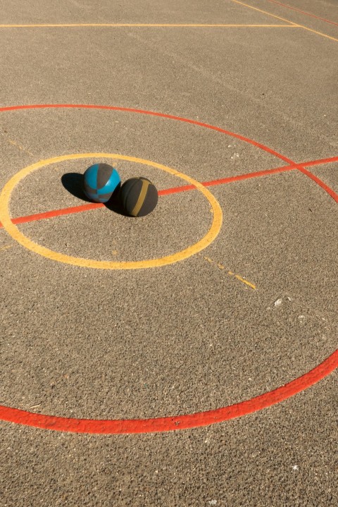 a basketball court with two balls in the middle of it