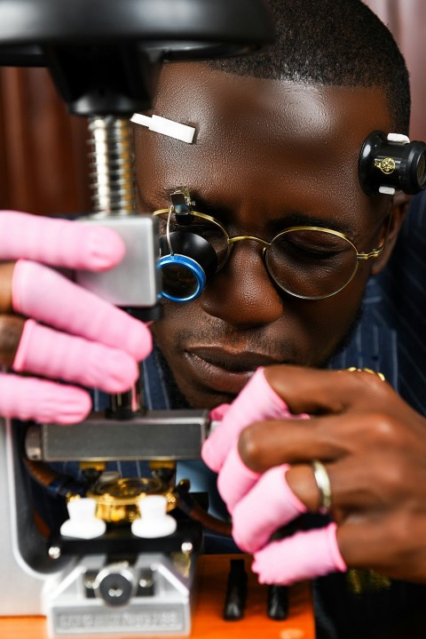 a man looking through a microscope at something