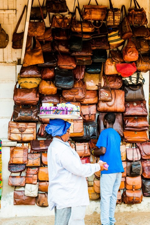 man standing beside brown leather bag lot