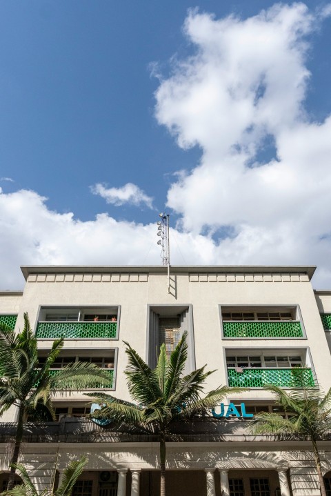 a building with palm trees and a antenna on top Lz