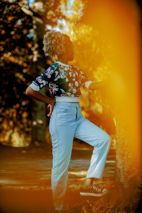 a woman standing next to a tree in a park