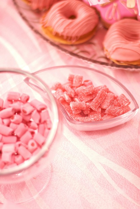 a table topped with donuts and pink sprinkles