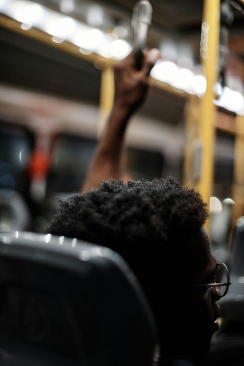 a man sitting on a train holding a cell phone