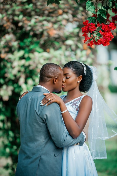 a bride and groom embracing under a tree