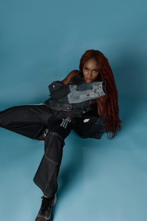 a woman with red hair sitting on a blue background R