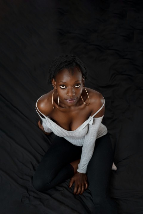 woman in white knit sweater and black pants sitting on black textile