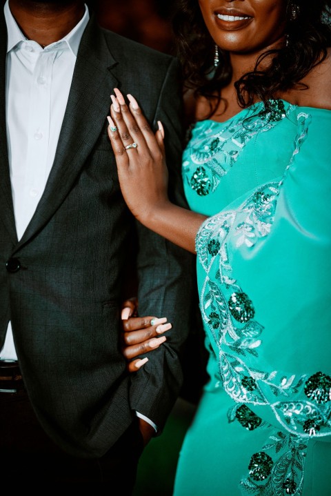 a woman in a green dress standing next to a man in a suit