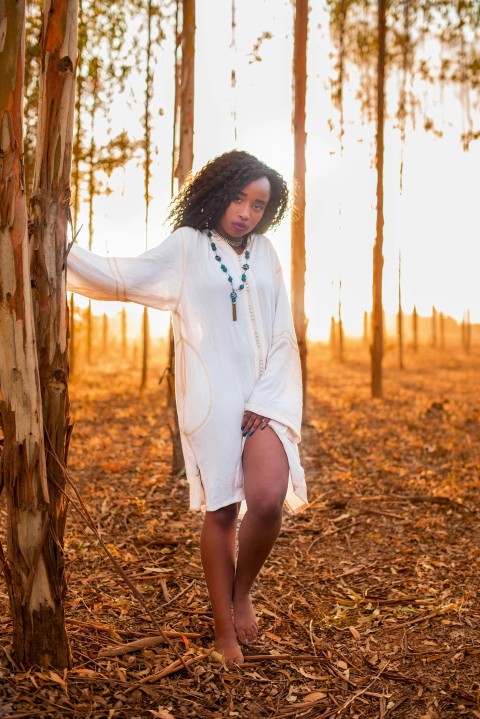 woman in white long sleeved dress near tree during daytime