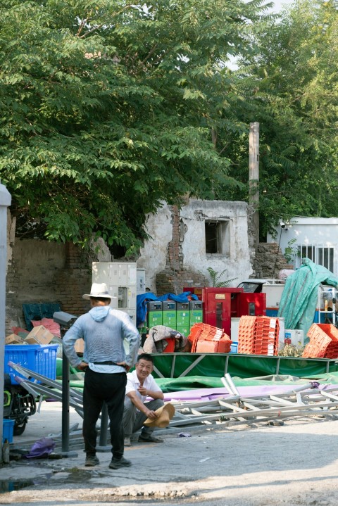 a man standing next to a pile of junk