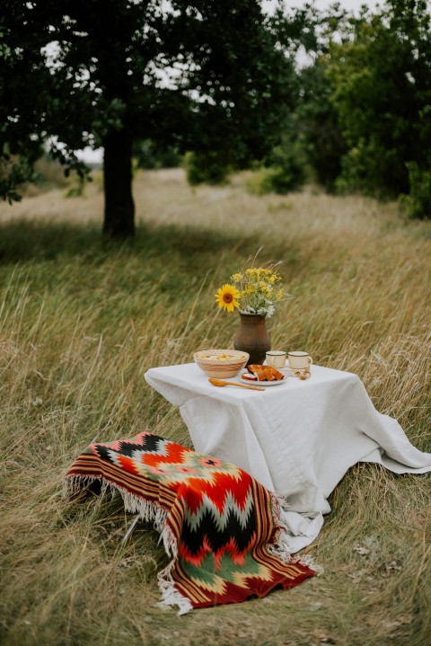 a table with a flower pot and cups on it