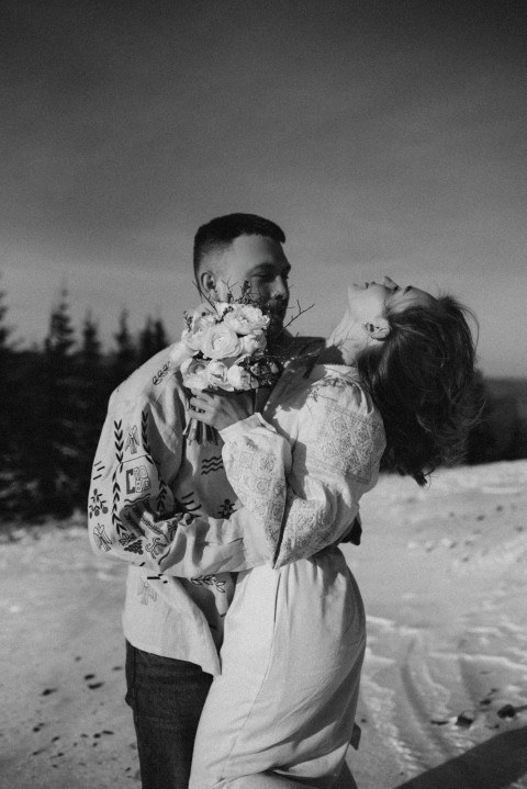 a man holding a woman in the snow