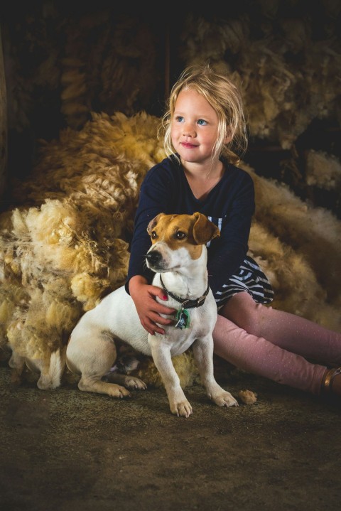 girl in blue long sleeved shirt holding brown and white jack russel terrier 9U5xMsmK