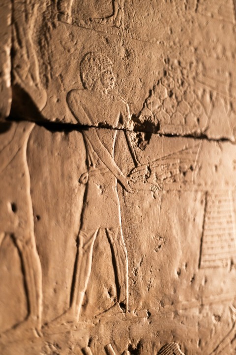 a close up of a stone wall with carvings on it Ts6uVfn