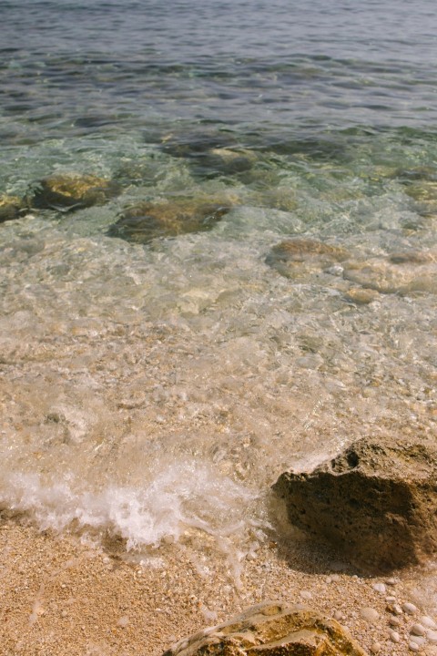 a person standing on a beach next to a body of water